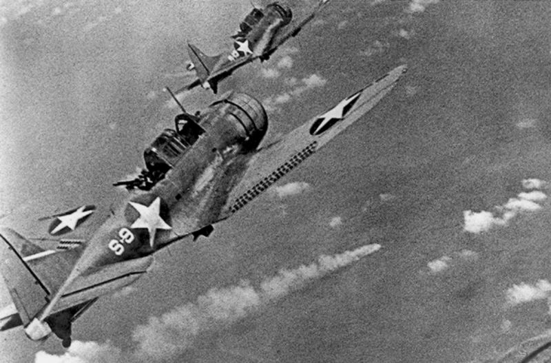 US Navy Douglas SBD Dauntless dive bombers from USS Hornet fly over the burning Japanese cruiser Mikuma during the Battle of Midway (US Navy)